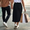 couple walks hand-in-hand down sidewalk