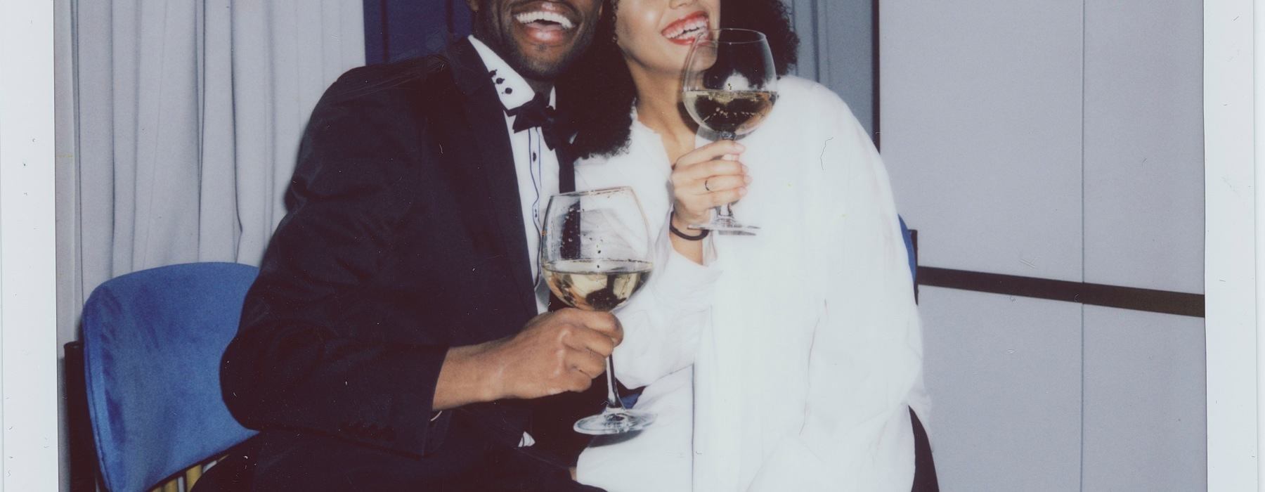 Couple smiling holding wine glasses on Valentine's Day