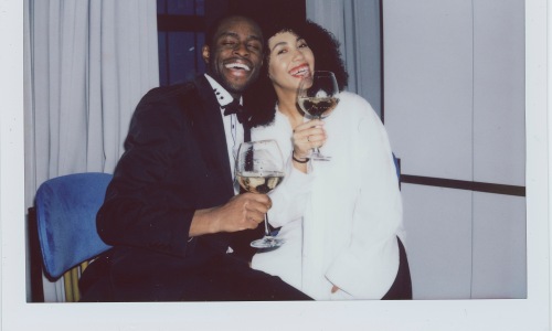 Couple smiling and holding wine glasses on Valentine's Day