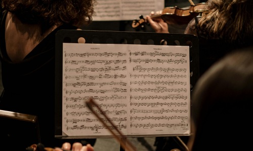 sheet music in front of violins | Stellar Seattle