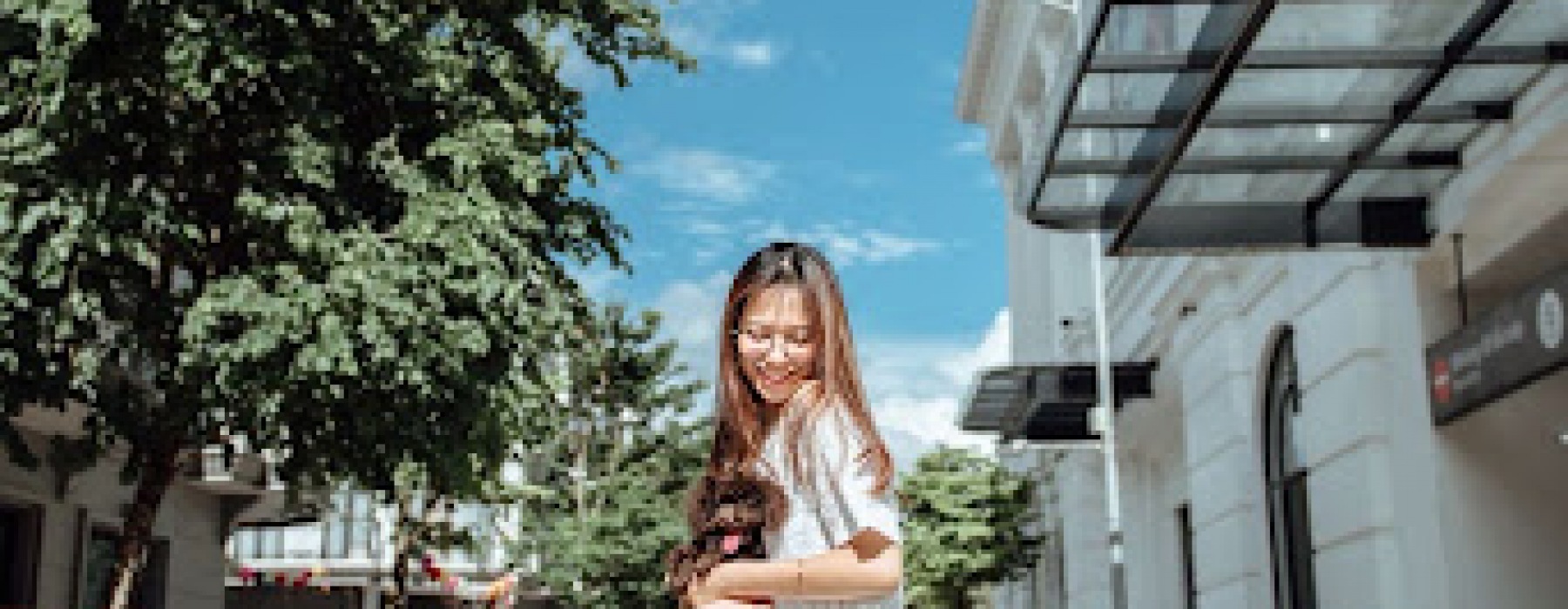Girl holding small cute dog outside of apartment building